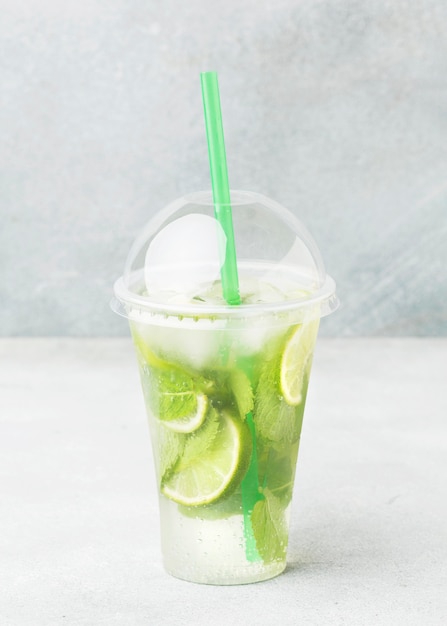 Vue de face de la tasse avec boisson gazeuse et citron vert