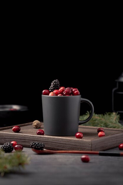 Vue de face de la tasse avec des canneberges et des mûres