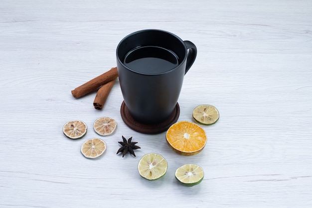 Vue de face tasse de thé au citron et cannelle sur blanc