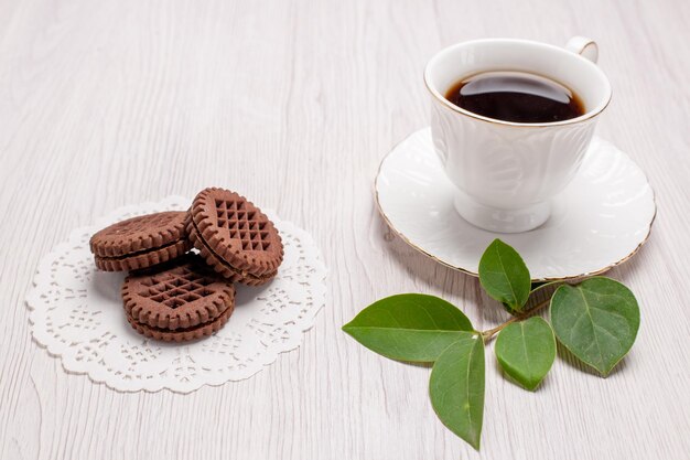 Vue de face tasse de thé avec des biscuits sur une table blanche biscuit au thé au sucre biscuit sucré