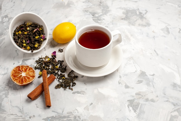 Vue de face tasse de thé avec du citron et de la cannelle sur un espace blanc