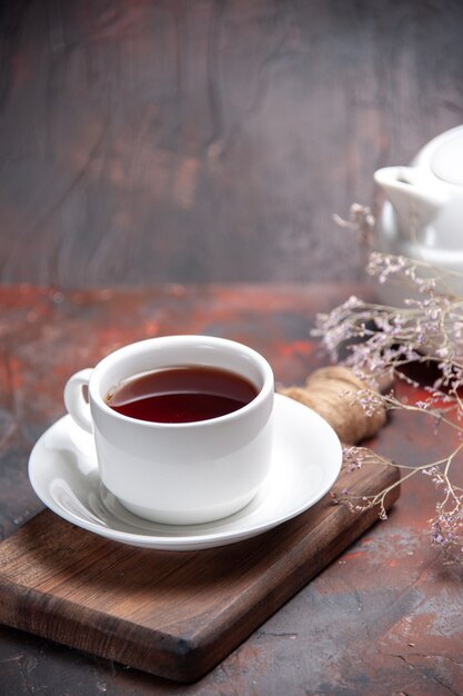 Vue de face tasse de thé sur la table sombre biscuit foncé