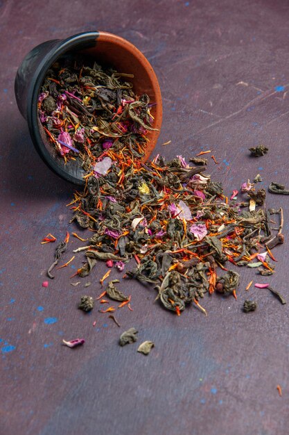 Vue de face thé frais séché sur fond sombre saveur de fleur de poussière de thé de plante