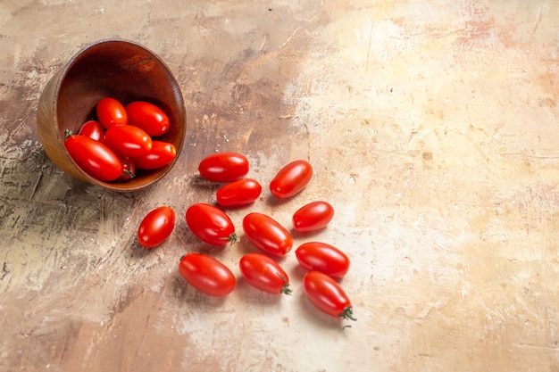 Photo gratuite vue de face des tomates cerises dispersées dans un bol sur de l'ambre