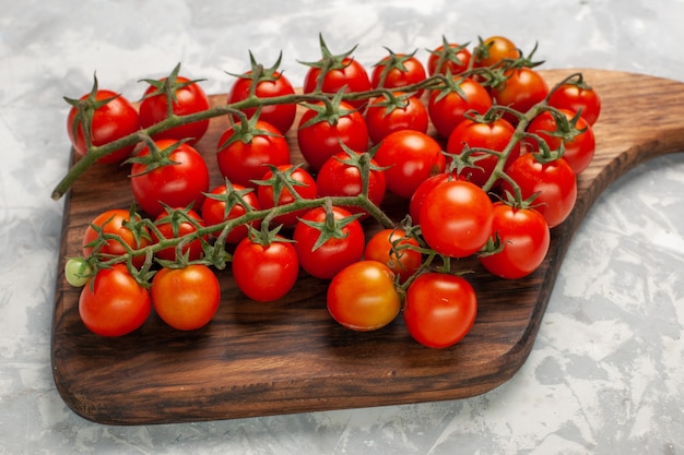 Vue de face tomates cerises fraîches légumes entiers mûrs sur surface blanche repas de légumes salade santé alimentaire