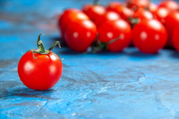 Vue de face des tomates fraîches sur la table bleue