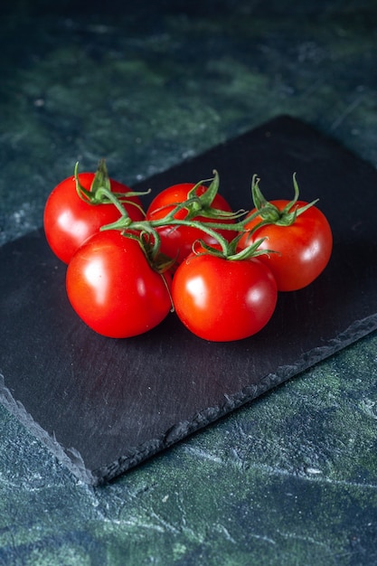 Vue de face tomates rouges fraîches sur fond sombre salade de légumes couleur de repas de nourriture mûre