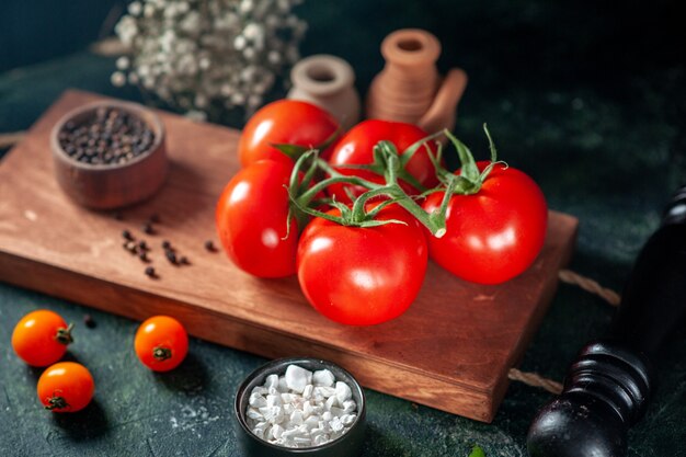 Vue de face tomates rouges fraîches sur fond sombre