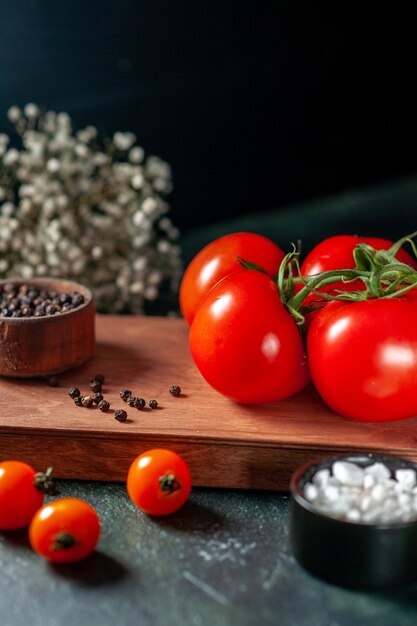 Vue de face tomates rouges fraîches sur fond sombre