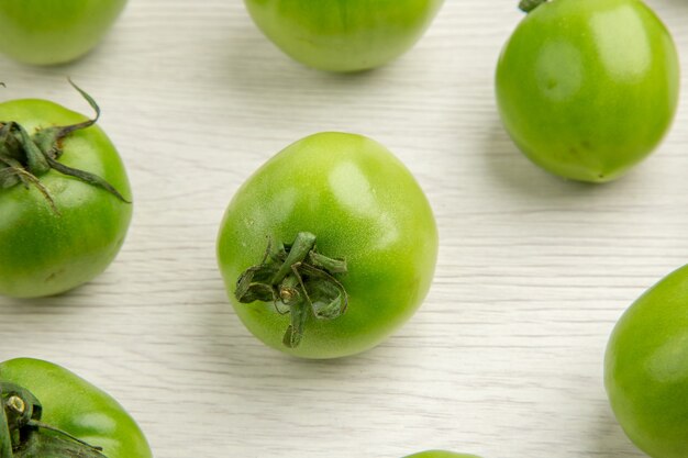 Vue de face tomates vertes sur un bureau blanc couleur salade mûre repas photo vie saine régime alimentaire