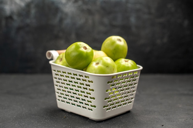 Vue de face des tomates vertes à l'intérieur du panier sur fond sombre