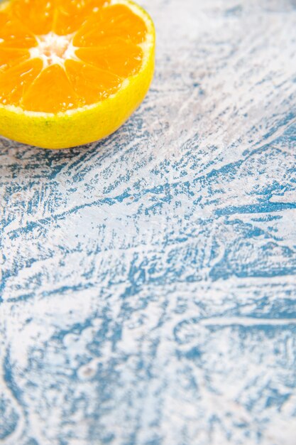 Vue de face tranche de mandarine fraîche sur la table bleu clair