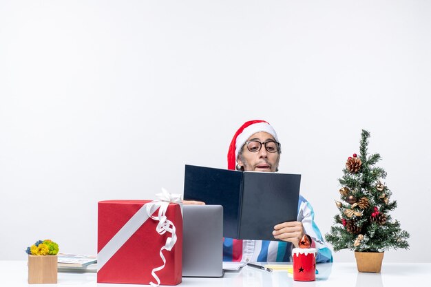 Vue de face travailleur masculin assis dans son cahier de lecture de lieu de travail