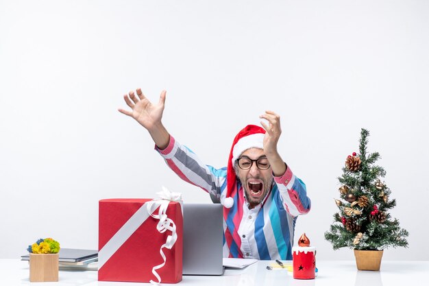 Vue de face travailleur masculin assis à sa place à l'aide d'un ordinateur portable criant émotion bureau travail de Noël
