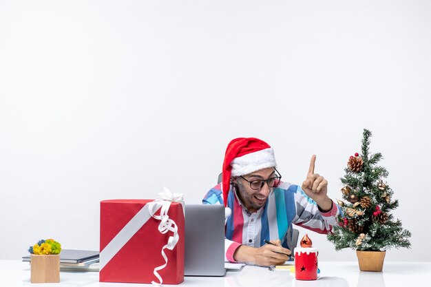 Vue de face travailleur masculin assis sur son lieu de travail, écrivant des notes travail d'affaires émotion de Noël