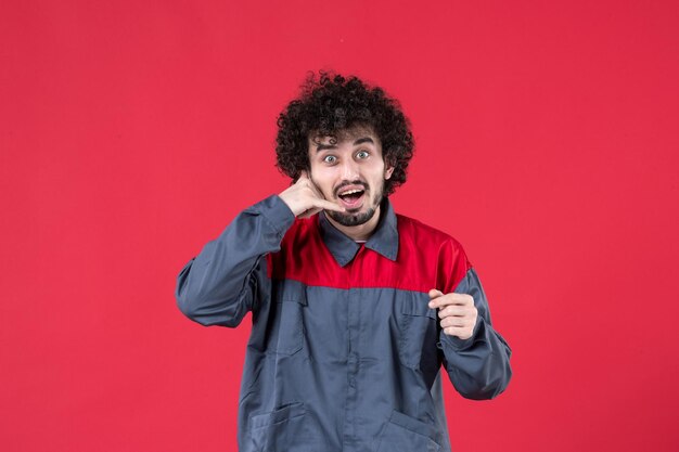 Vue de face travailleur masculin en uniforme sur rouge