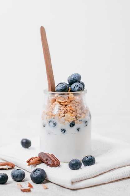 Photo gratuite vue de face verre de lait frais avec de l'avoine et des bleuets