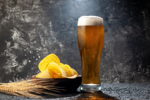 Vue de face verre d'ours avec cips sur photo sombre boisson alcoolisée couleur vin snack