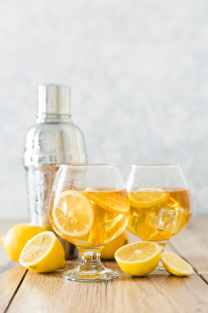 Vue de face de verres avec boisson au citron et shaker