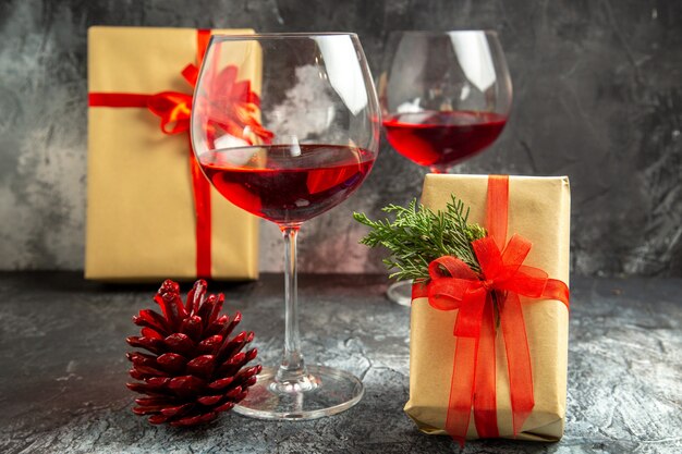 Vue de face des verres de vin cadeaux de Noël sur dark