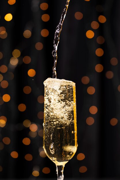 Vue de face versant du champagne en verre