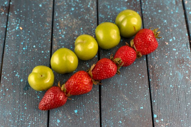 Photo gratuite une vue de face vert cerise-prunes moelleuses et aigres avec des fraises rouges fraîches isolées