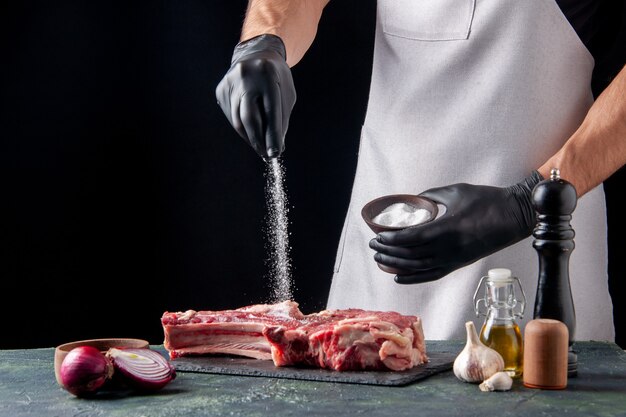 Vue de face de la viande de boucher mâle sur une surface sombre