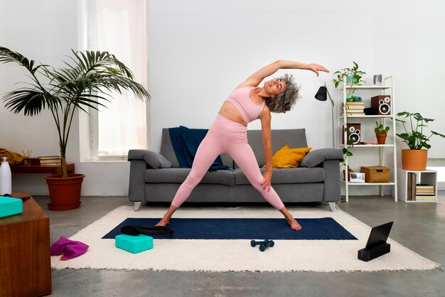 Vue de face vieille femme faisant de l'exercice à la maison