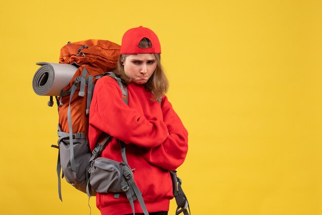 Vue de face voyageur femelle maussade avec sac à dos croisant les mains