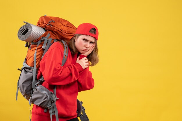 Vue de face voyageur femelle maussade avec sac à dos tenant son visage