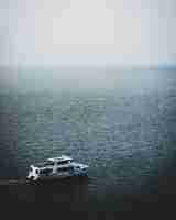 Photo gratuite vue fascinante du bateau dans la mer calme un jour brumeux