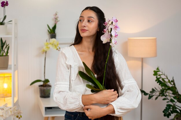 Photo gratuite vue d'une femme décorant sa maison avec des orchidées