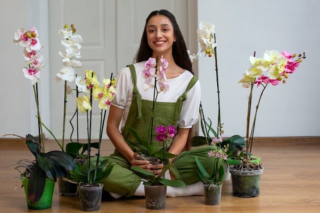 Vue d'une femme décorant sa maison avec des orchidées