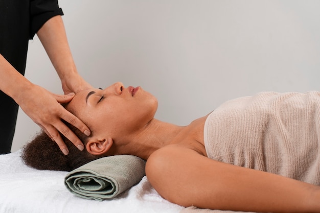 Photo gratuite vue d'une femme recevant un massage facial de yoga pour rester jeune