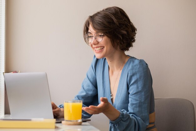 Vue d'une femme souriante sur un ordinateur portable à la maison