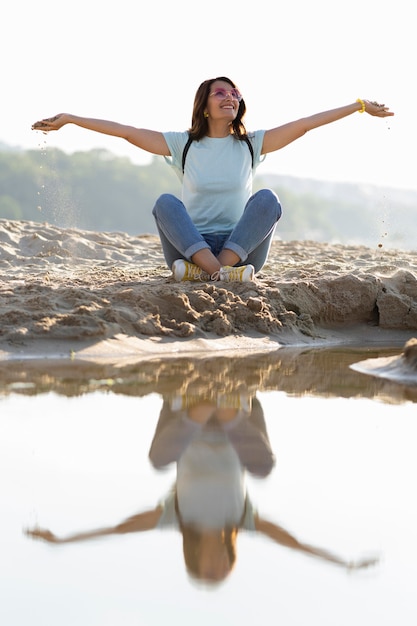 Photo gratuite vue frontale, de, femme assise, sur, plage sable