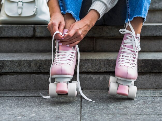 Vue frontale, de, femme, sur, escalier, attacher, lacets, sur, patins a roulettes