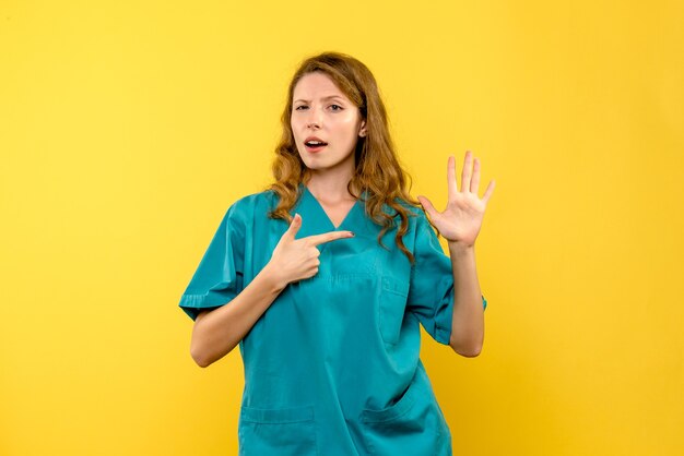 Vue frontale, de, femme médecin, sur, mur jaune