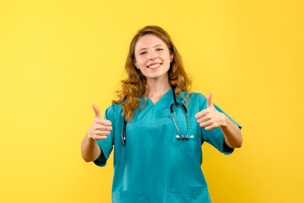 Vue frontale, de, femme médecin, sourire, sur, mur jaune