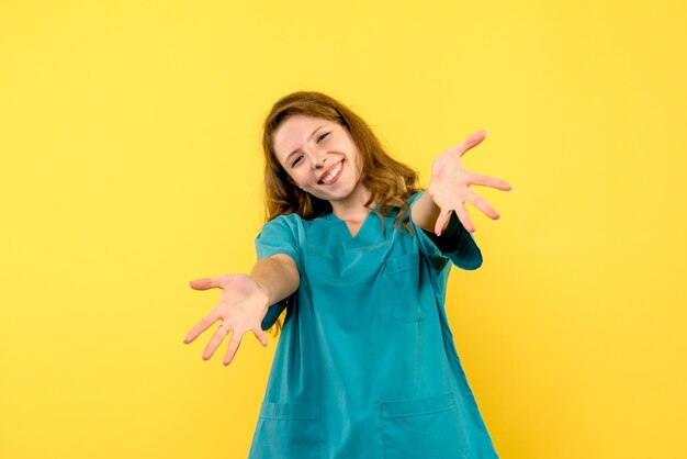 Vue frontale, de, femme médecin, sourire, sur, mur jaune