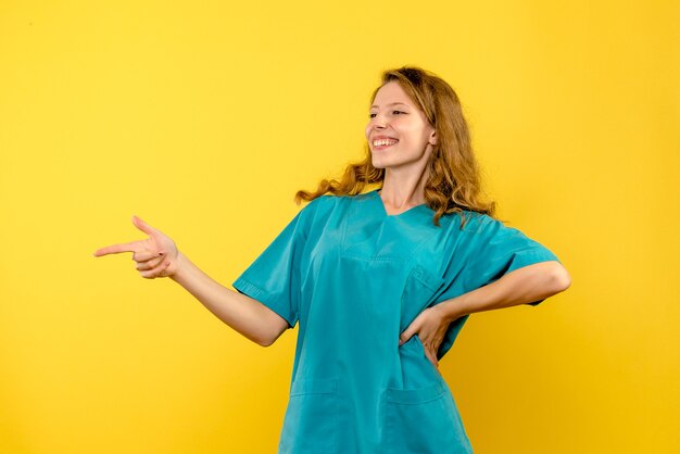 Vue frontale, de, femme médecin, sourire, sur, mur jaune