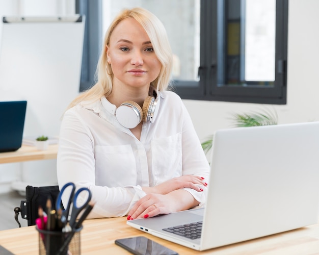 Vue frontale, de, femme souriante, dans, fauteuil roulant, poser, à, elle, bureau