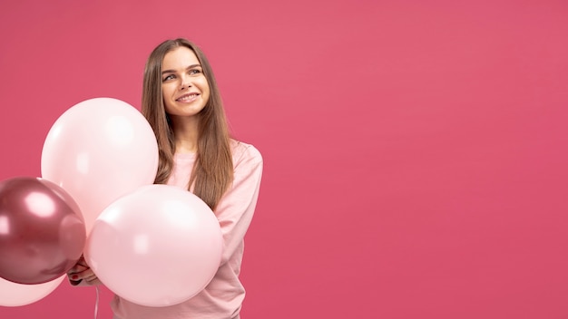 Photo gratuite vue frontale, de, femme souriante, poser, à, ballons