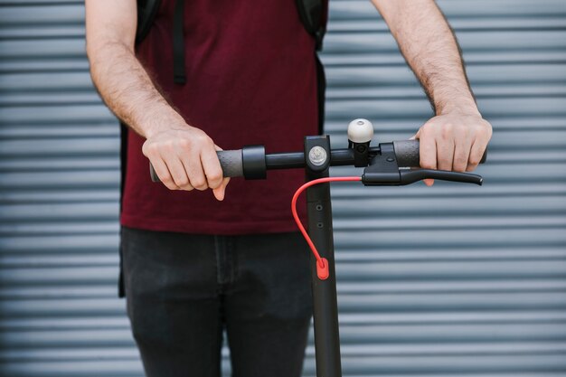 Vue frontale, homme, tenue, e-scooter, poignées