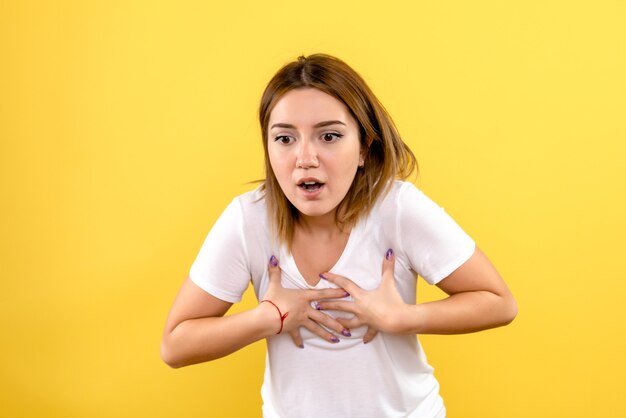 Vue frontale, de, jeune femme, sur, mur jaune