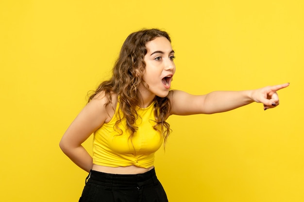 Vue frontale, de, jeune femme, pointage, sur, mur jaune