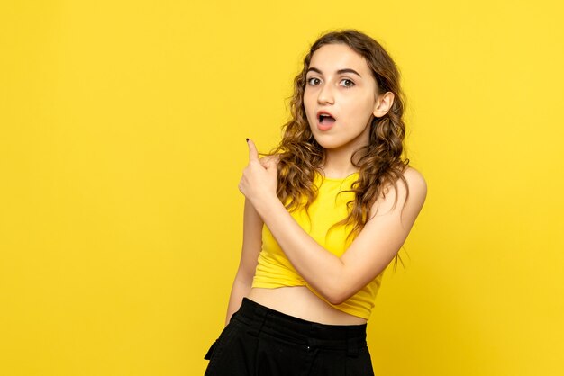 Vue frontale, de, jeune femme, surpris, sur, mur jaune