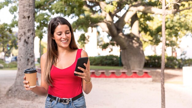 Vue frontale, jeune femme, tenue, café, et, téléphone