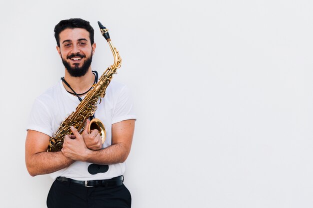 Vue frontale moyen coup musicien souriant avec saxophone