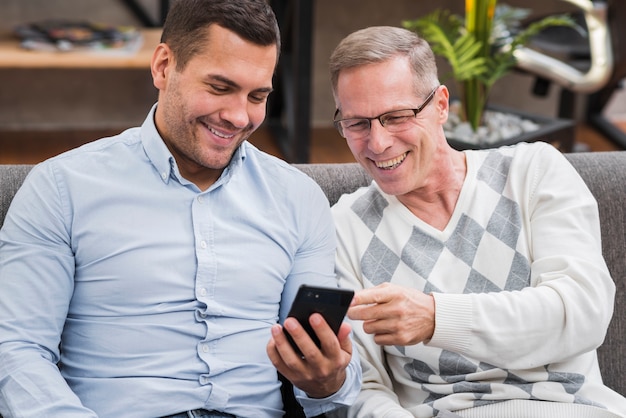 Vue frontale, de, père fils, regarder téléphone